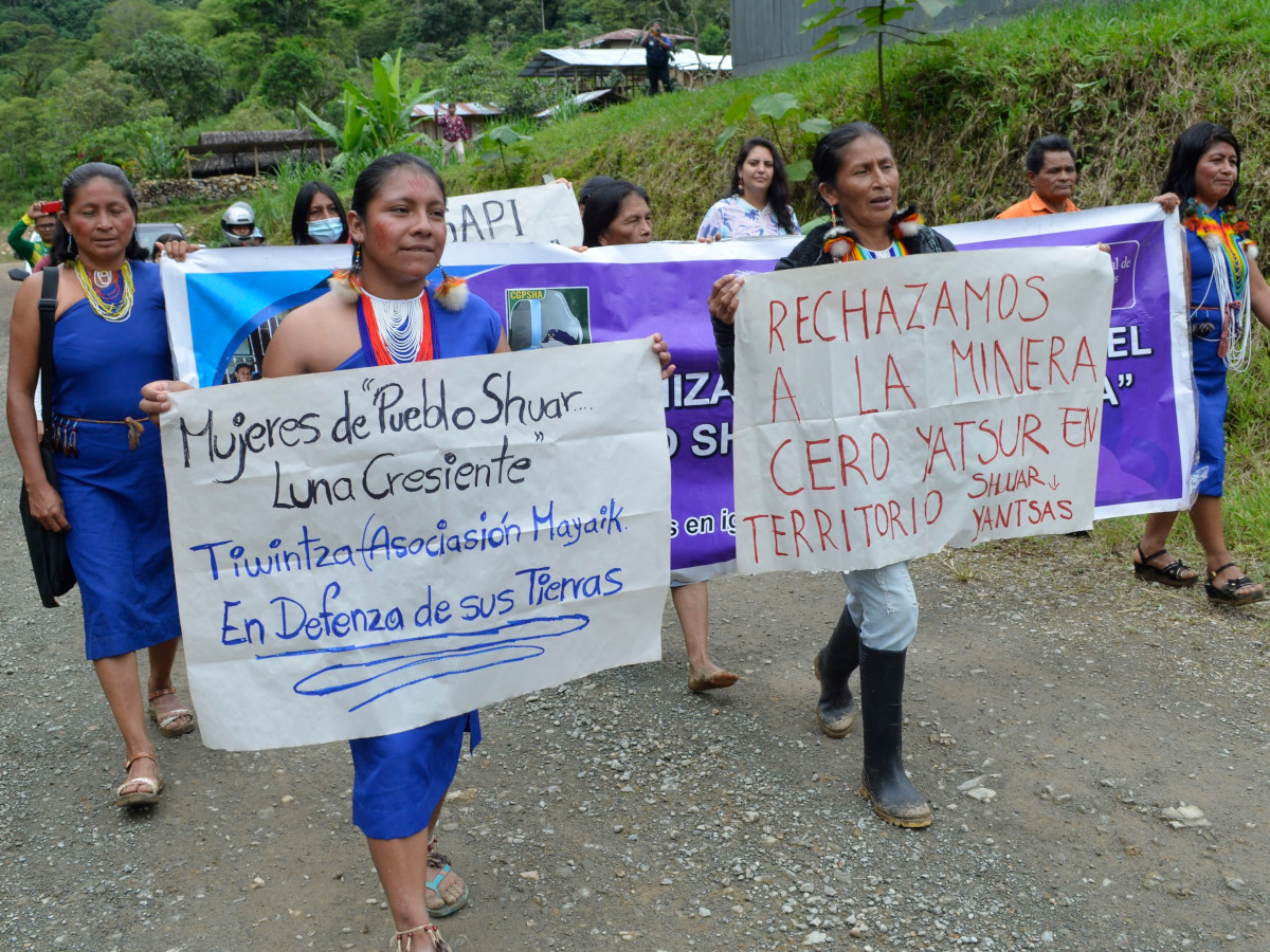 Shuar Indigenous women march with signs that convey their rejection of mining in their territory