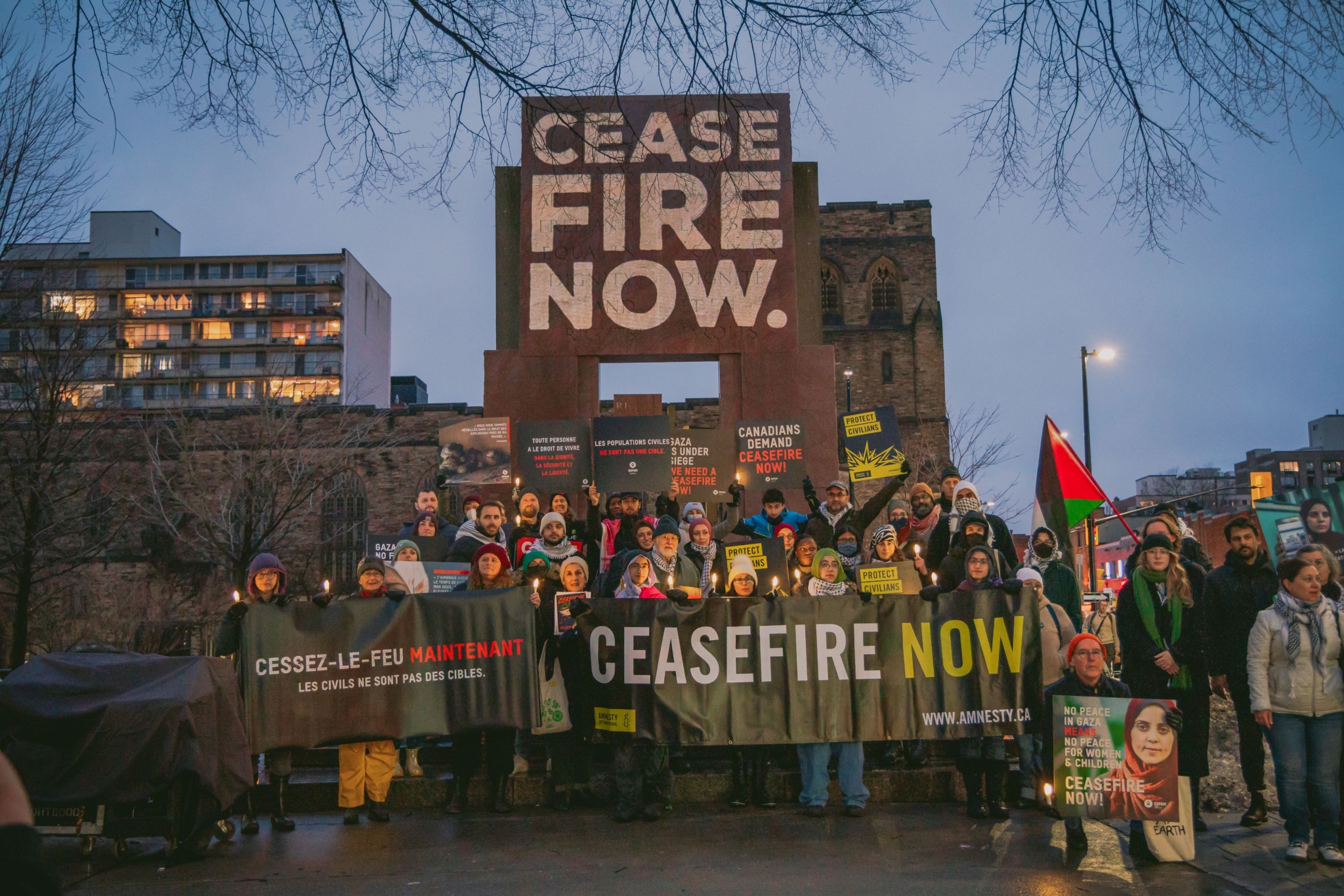 A group of more than 40 people pose outside with banners calling for a ceasefire in the Gaza Strip.