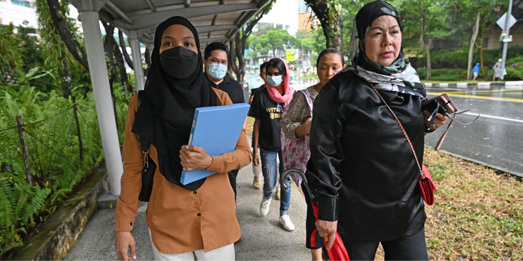 Sarah Binte Jumaat (left), sister of death row convict Syed Suhail, walks with other families members to the Ministry of Home Affairs to submit a petition in Singapore on October 9, 2023. Families of death row convicts urged the Singapore government to impose a moratorium on capital punishment to allow for an independent review of the controversial use of executions in the city-state. (Photo by Roslan Rahman/AFP via Getty Images)