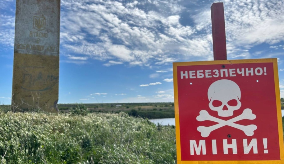 Mine sign by a river in in Kalynivka, Kharkiv oblast. © Amnesty International