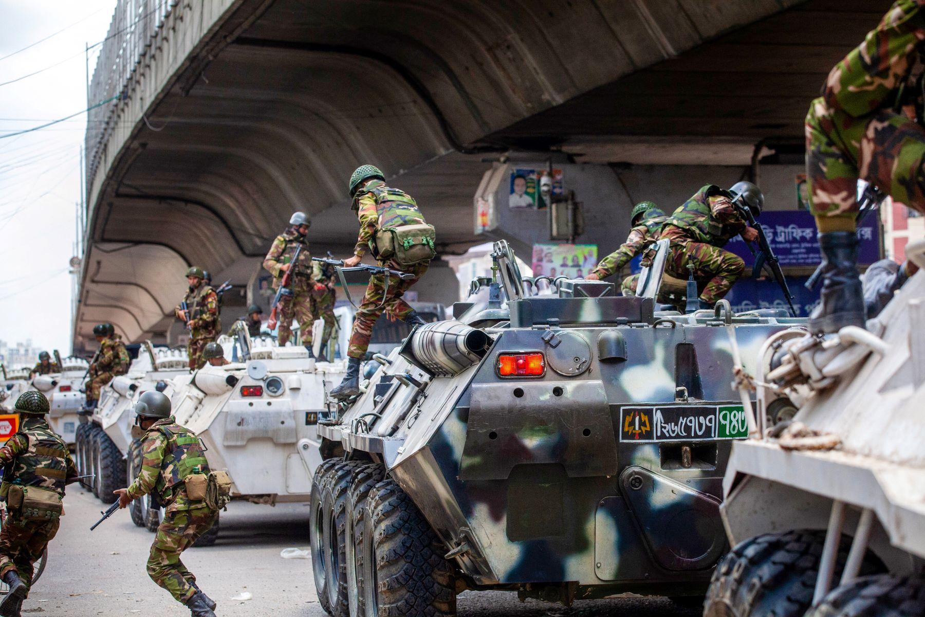 Bangladeshi soldiers disembark armored vehicles as they patrol the streets to disperse the anti-quota protesters in Dhaka on July 20, 2024. Photo by -/AFP via Getty Images.