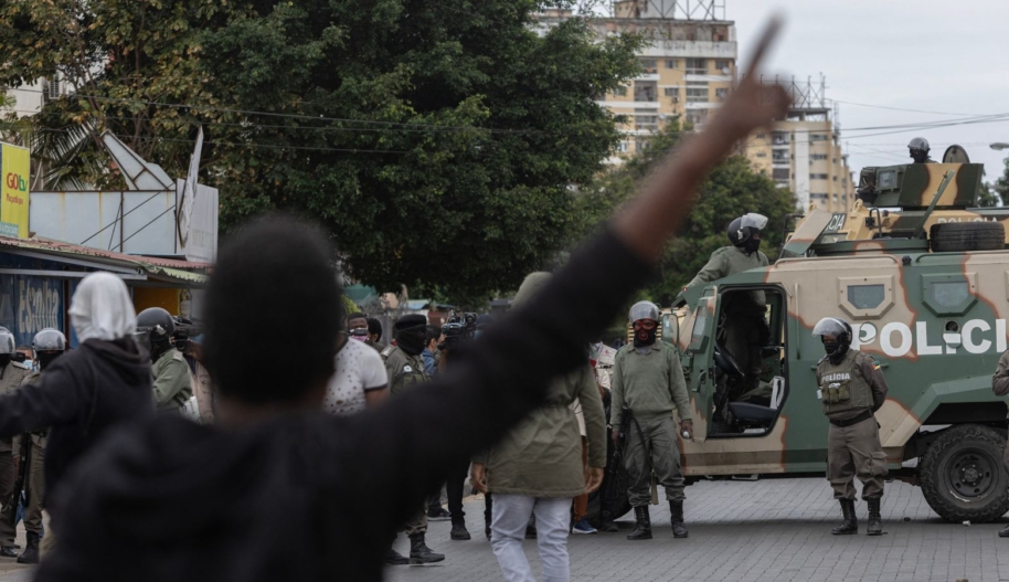 Protesters look on as Mozambique riot police officers block the road in Maputo, on November 7, 2024. (Photo by ALFREDO ZUNIGA/AFP via Getty Images)