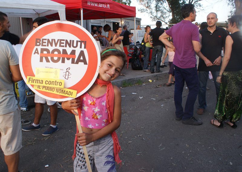 Little girl holding a sign and smiling at a protest