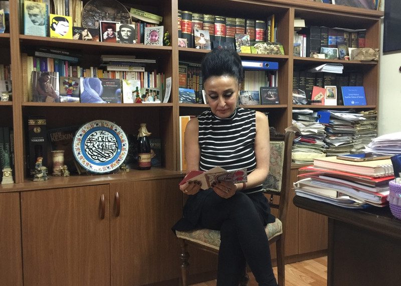 Woman sitting reading a book in her office