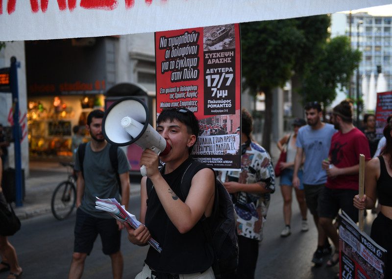 People protesting with a blow horn and signs