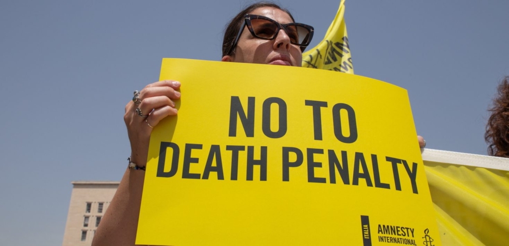 Woman holds up sign "No to Death Penalty"