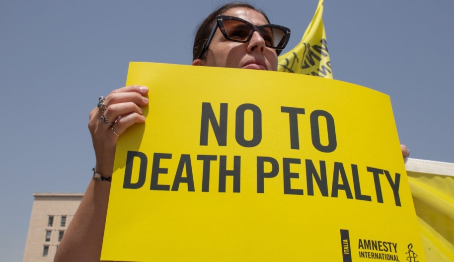 Woman holds up sign "No to Death Penalty"