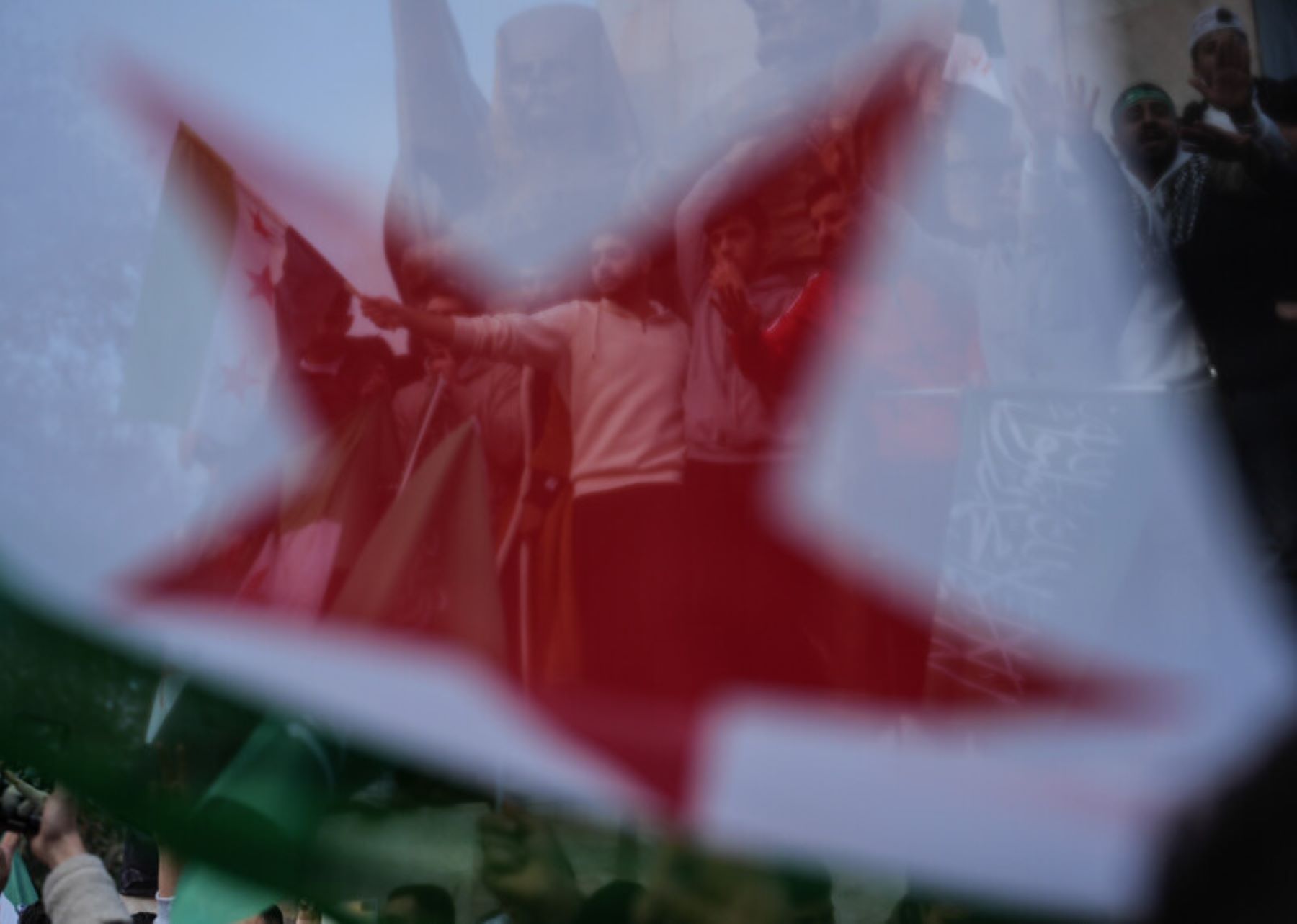 Syrian people living in Istanbul gather in Sarachane Park, Fatih district to celebrate with Syrian opposition's 'revolution flag' in their hands as sixty-one years of Baath Party rule in Syria collapses on Sunday when the capital Damascus fell out of the hands of regime control, on December 08, 2024 in Turkiye. (Photo by Hakan Akgun/Anadolu via Getty Images)