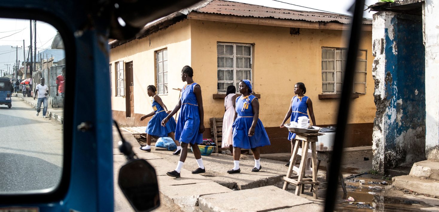 5 women exiting a building wearing blue dresses