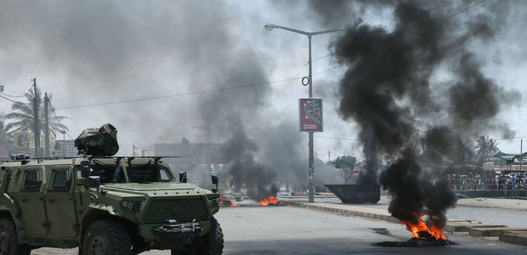 An armored military vehicle stands next to a burning tyre during a demonstration against the government in Maputo on December 6, 2024.Photo by AMILTON NEVES/AFP via Getty Images.
