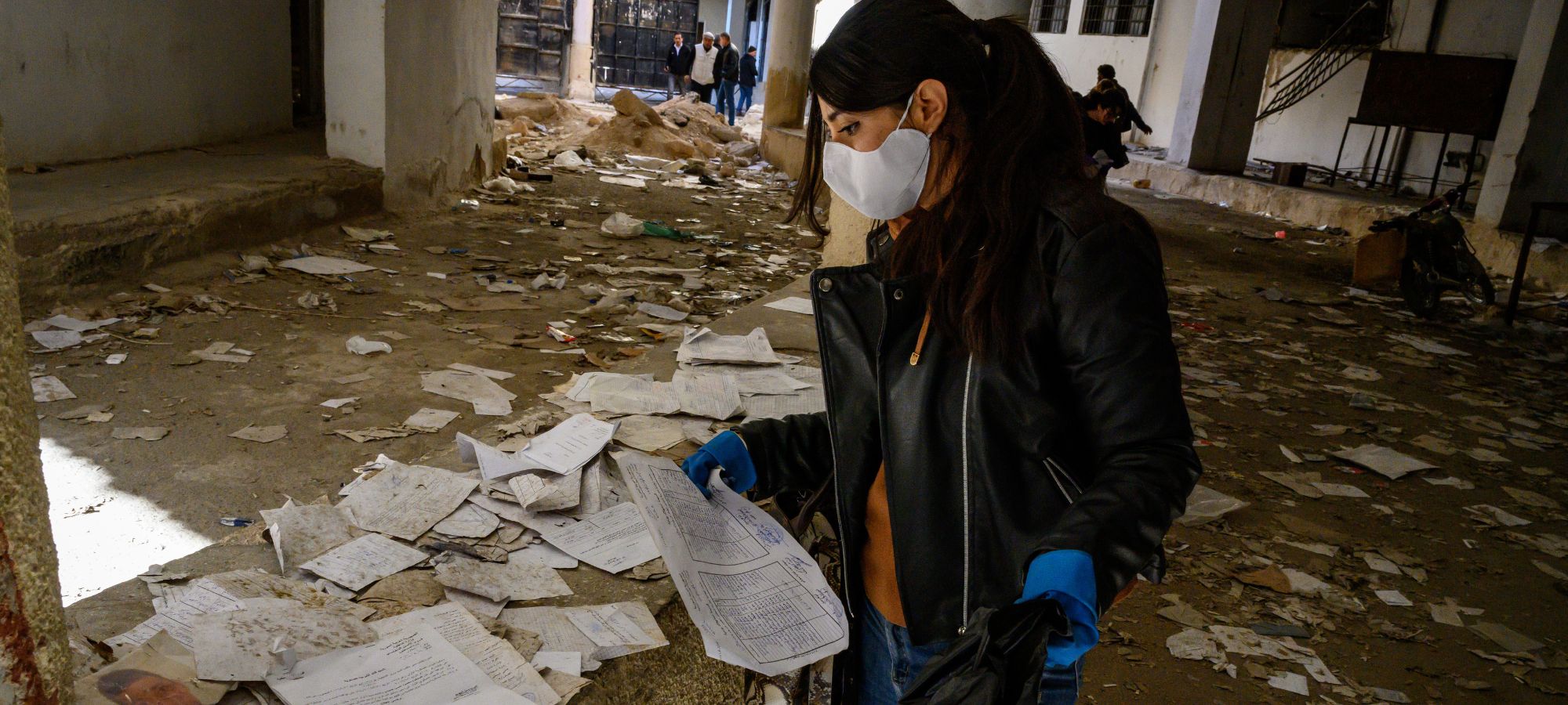 A volunteer collects documents to preserve, as Syrians search and inspect Sednaya Prison, where thousands of people were detained and tortured by the Assad regime, on December 14, 2024 in Damascus, Syria.
