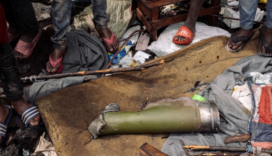 Bystanders observe a shell casing Goma DRC ©Philémon Barbier / Hors Format / Amnesty International