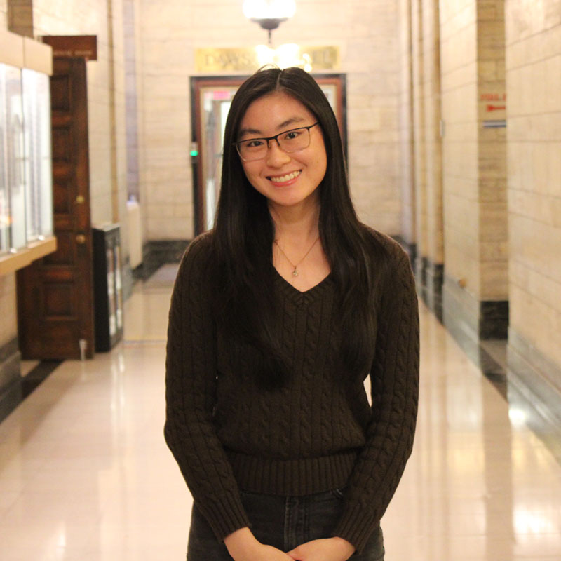 Young woman standing and smiling in hallway of official building