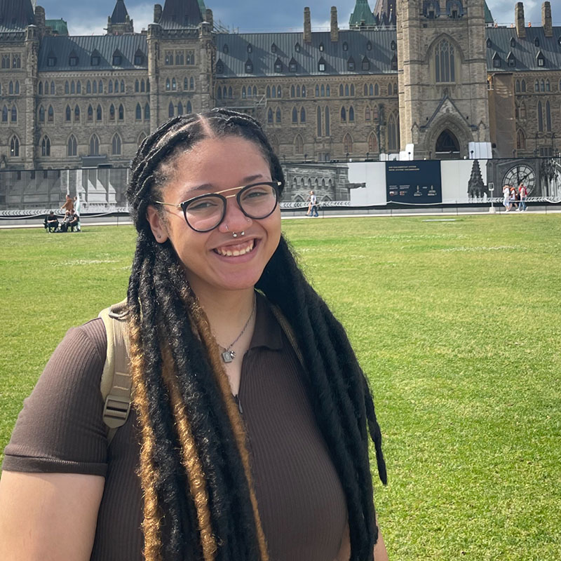 Young woman standing in yard outside of a parliament building