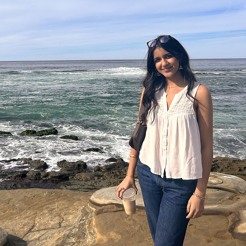 Young woman standing in front of ocean on the beach