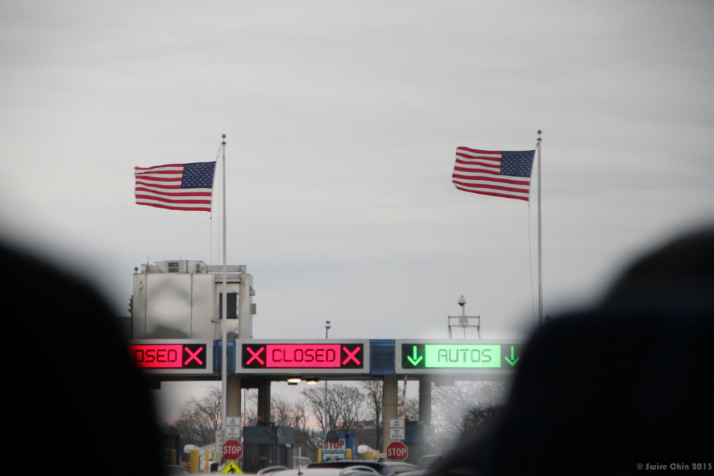 American flags fly over electric signs at the Canada.-U.S. border