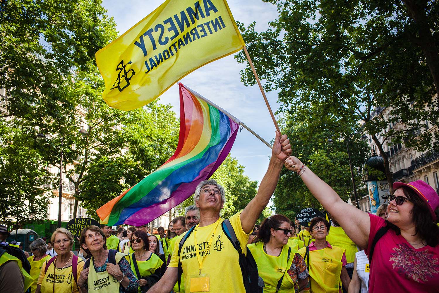 Amnesty supporters in a march waving an Amnesty International flag