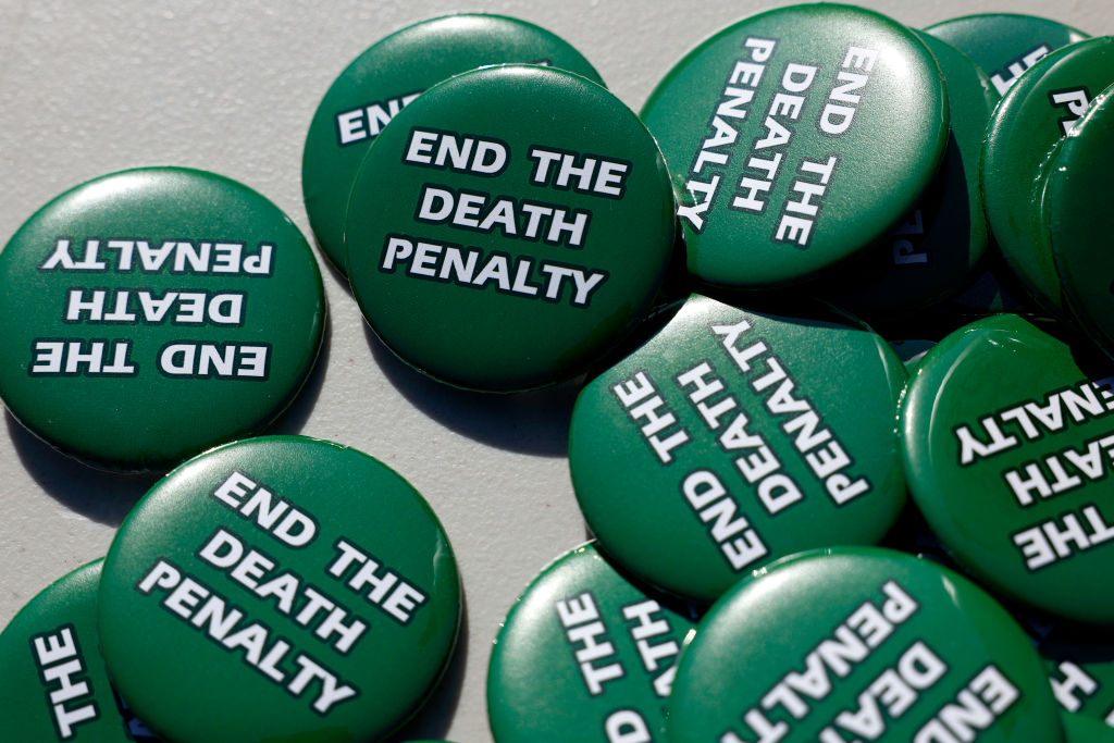 A bunch of identical circular green pins that with the text "End the Death Penalty" printed in bold white text on each