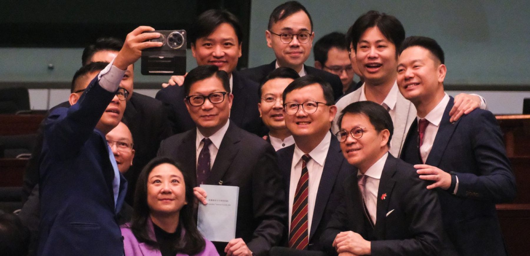 Hong Kong Secretary for Security Chris Tang Ping-keung (C) and lawmakers take a selfie after a meeting for Basic Law Article 23 legislation at the Legislative Council on March 19, 2024. Photo by Chen Yongnuo/China News Service/VCG via Getty Images.