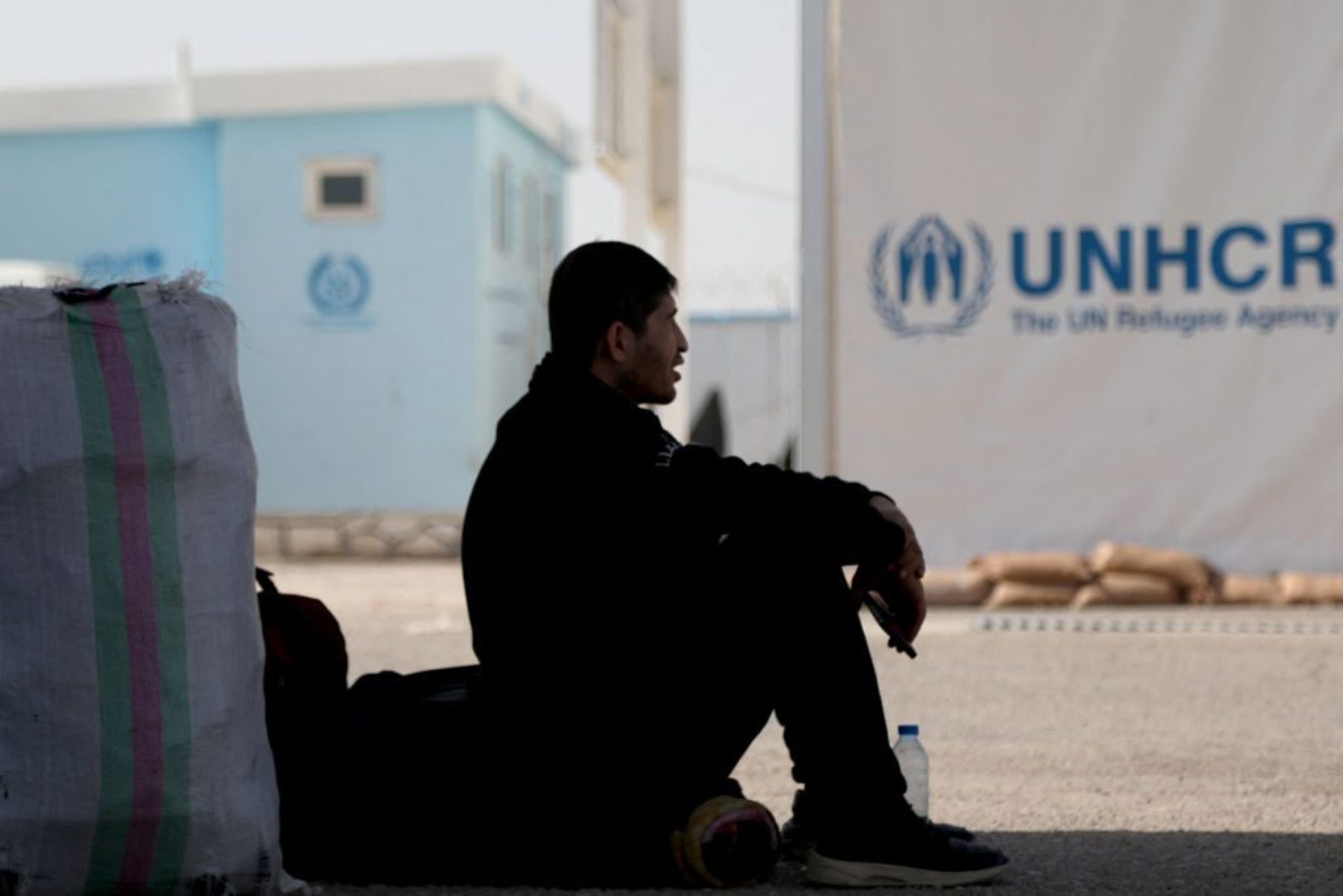An Afghan migrant who was living in Iran as a refugee, sits near UNHCR center after being deported back to Afghanistan at the zero point between Afghanistan and Iran in Islam Qala in Herat province on February 23, 2025. Photo by MOHSEN KARIMI/AFP via Getty Images.