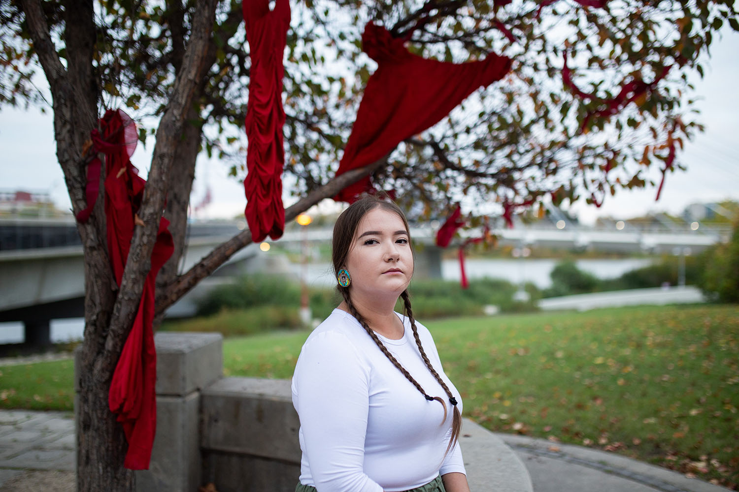 Women standing in front of tree with red dresses hanging from it