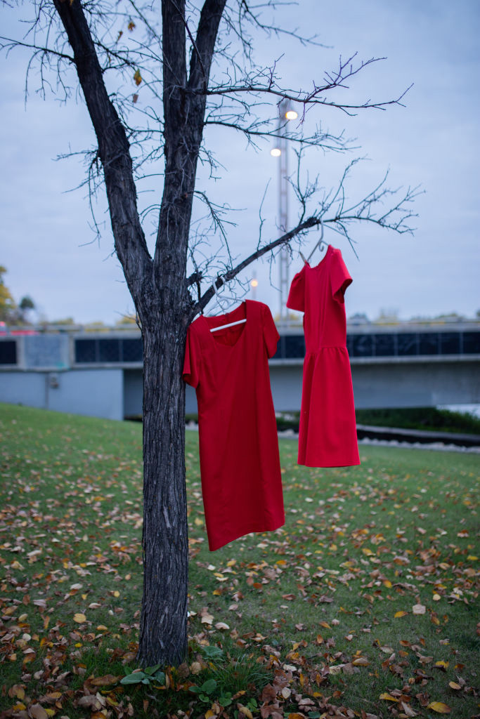 Red dresses hanging from a tree