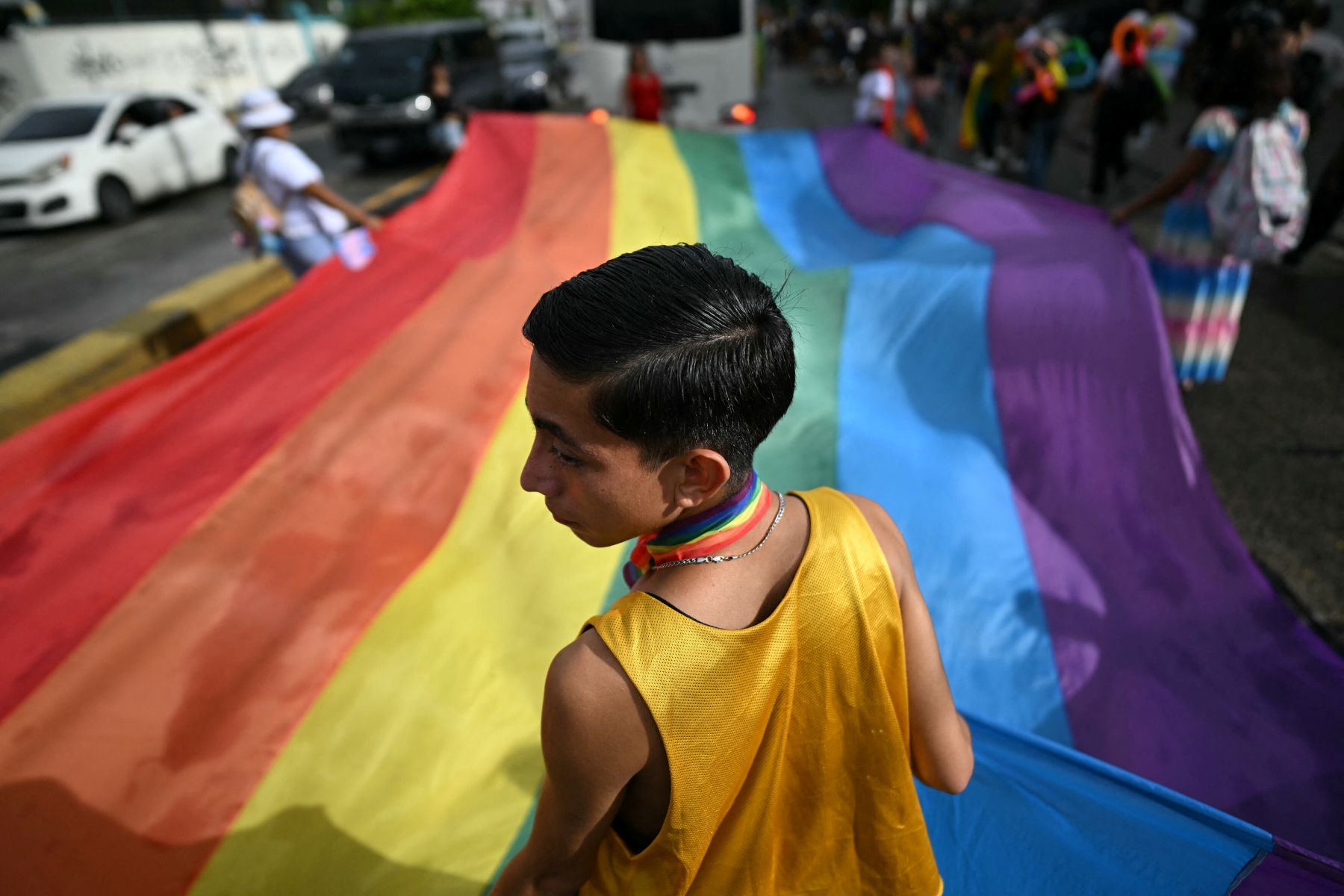 Supporters of the LGBTQ community hold a large rainbow flag as they take part in the Pride March in San Salvador on June 29, 2024. Photo by MARVIN RECINOS/AFP via Getty Images.