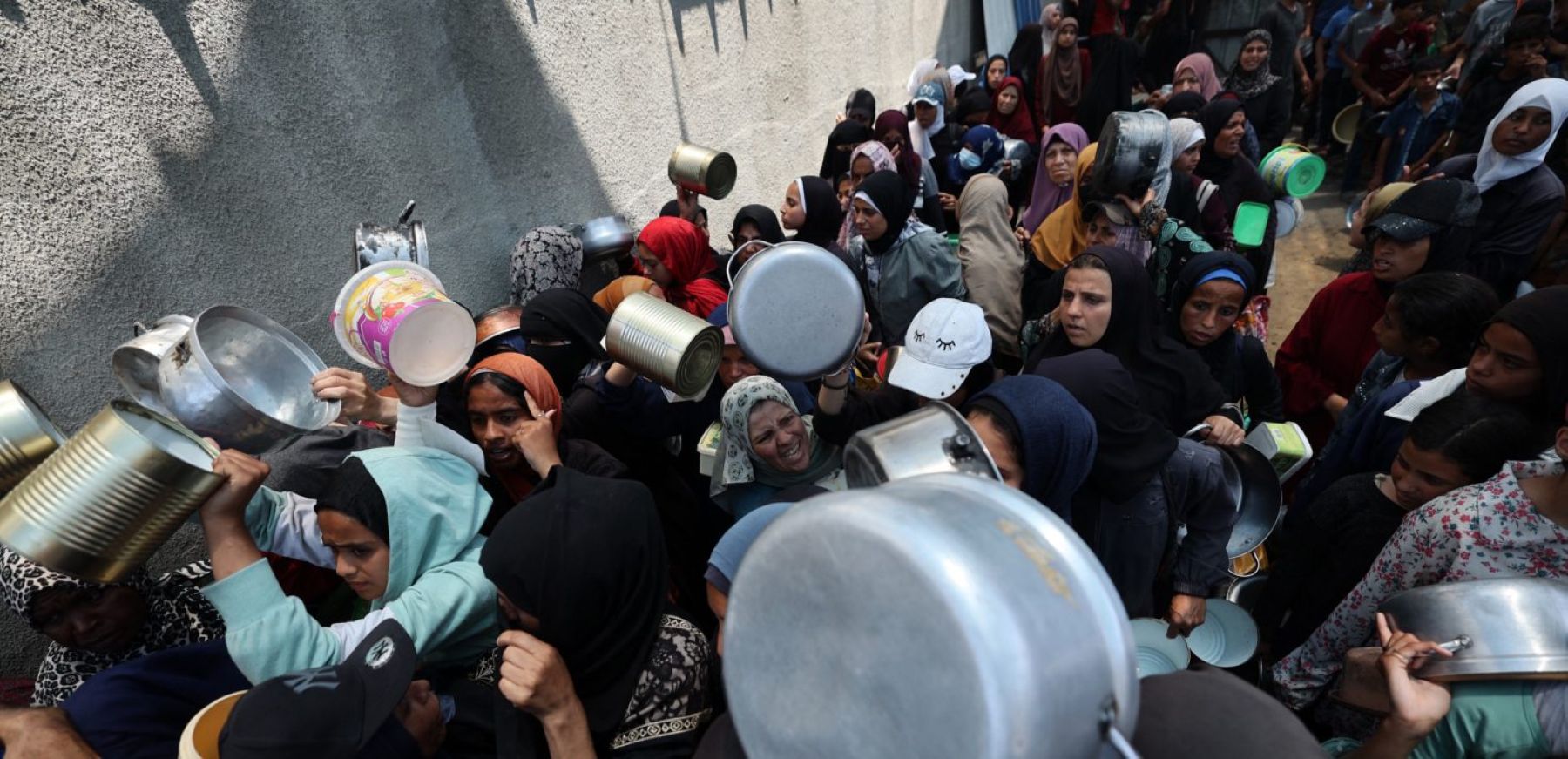 Palestinian women gather at a hot meal distribution point in Nuseirat in the central Gaza Strip, June 4, 2025. Photo by EYAD BABA/AFP via Getty Images.