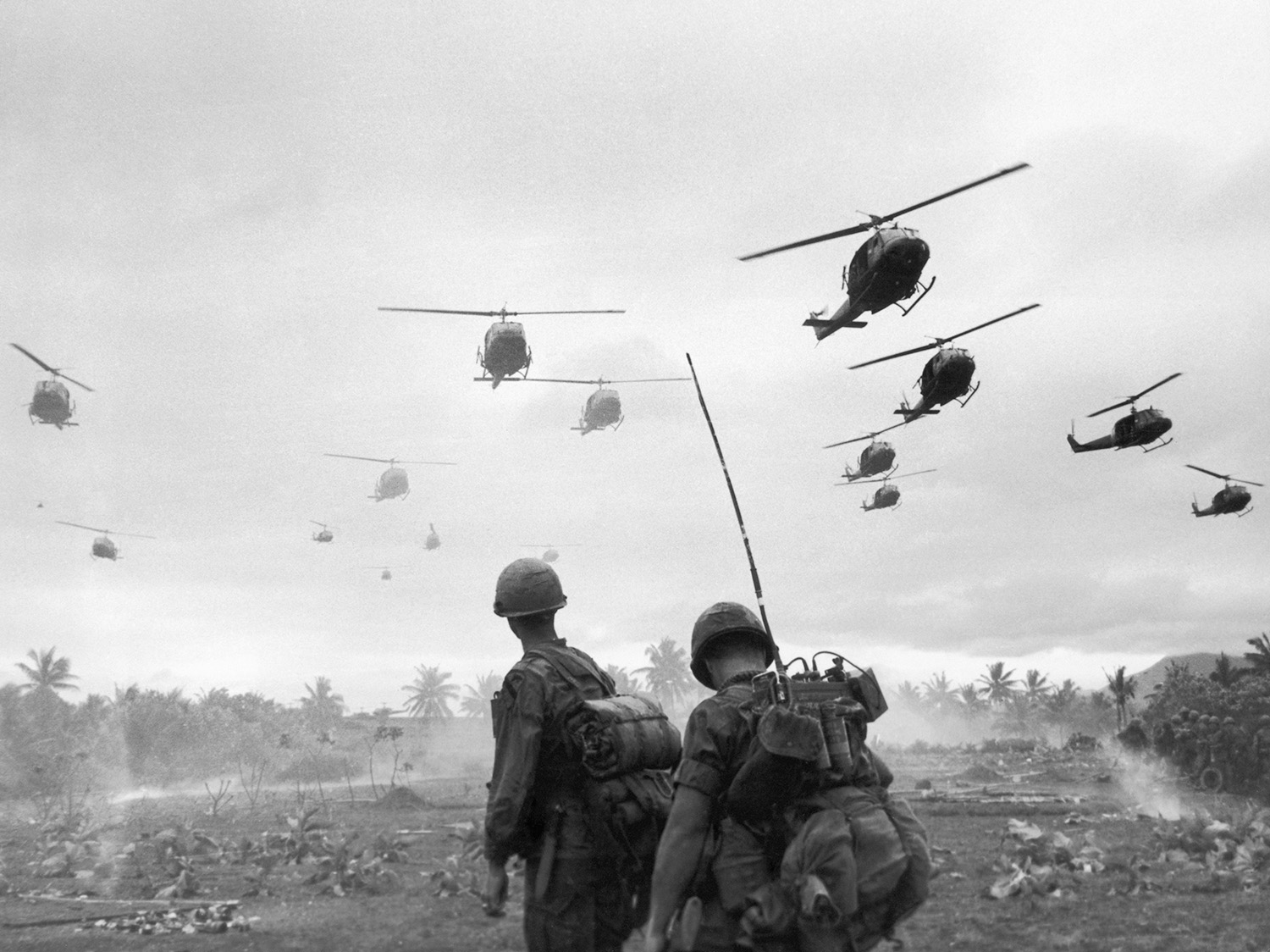 2 Soldiers looking up at helicopters