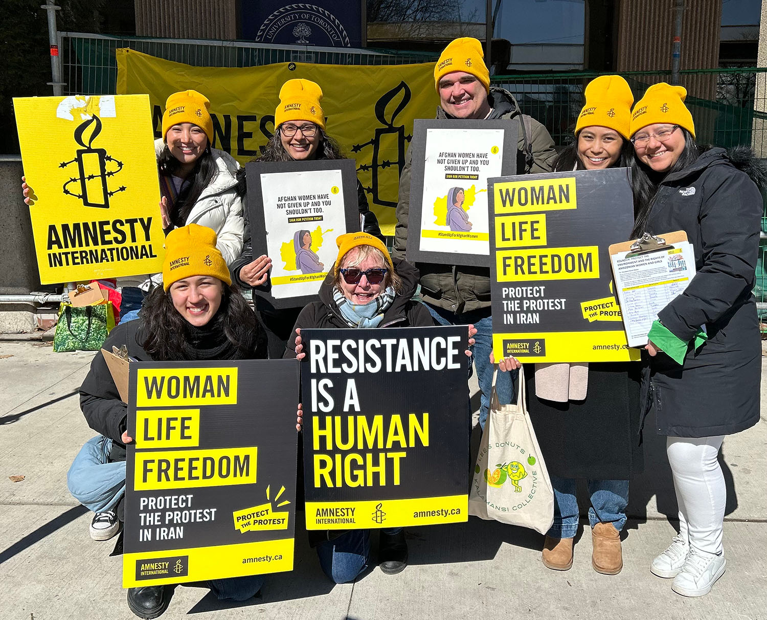 Amnesty staff holding up posters and signsfor human and gender rights