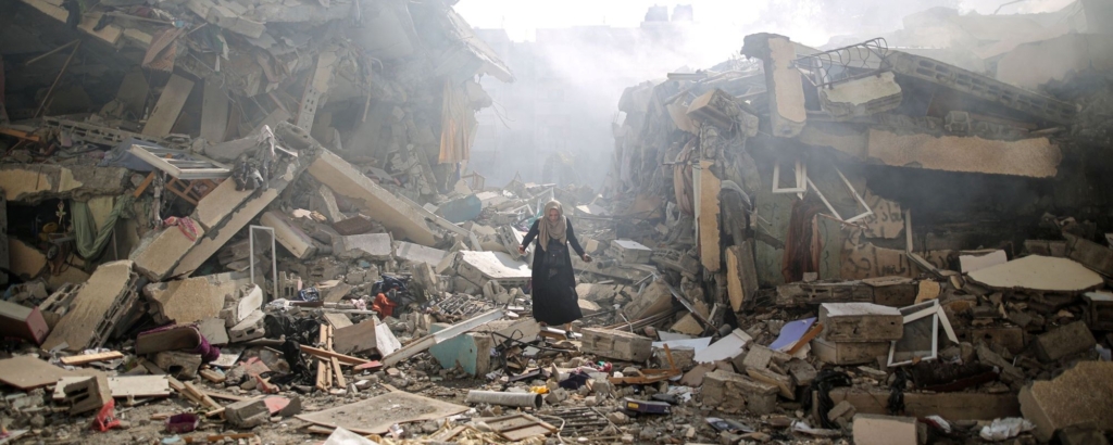 A woman walks through rubble of residential buildings after Israeli airstrikes at al-Zahra neighborhood in Gaza Strip on October 19, 2023. Photo by Mustafa Hassona/Anadolu via Getty Images.