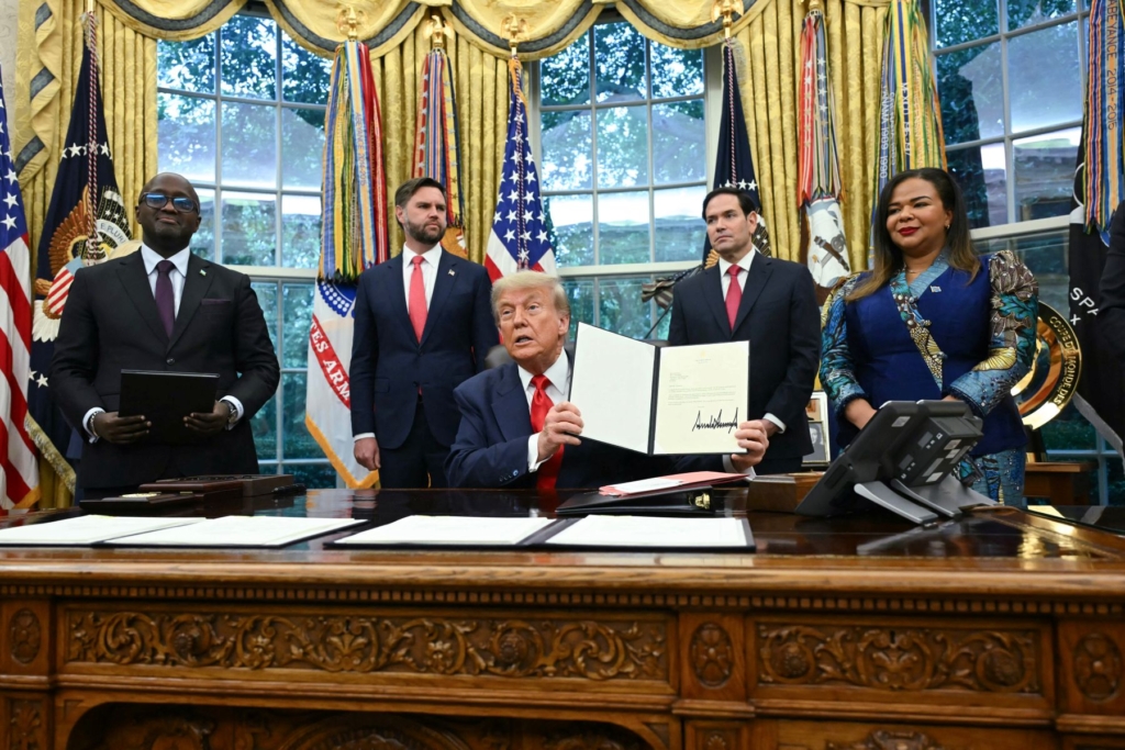 US President Donald Trump holds a letter addressed to Congolese President Felix Tshisekedi congratulating him on the peace agreement with Rwanda during a meeting with Democratic Republic of the Congo Foreign Minister Thérèse Kayikwamba Wagner (R) and Rwandan Foreign Minister Olivier Nduhungirehe (L) in the Oval Office of the White House in Washington, DC, on June 27, 2025. Photo by ANDREW CABALLERO-REYNOLDS/AFP via Getty Images.