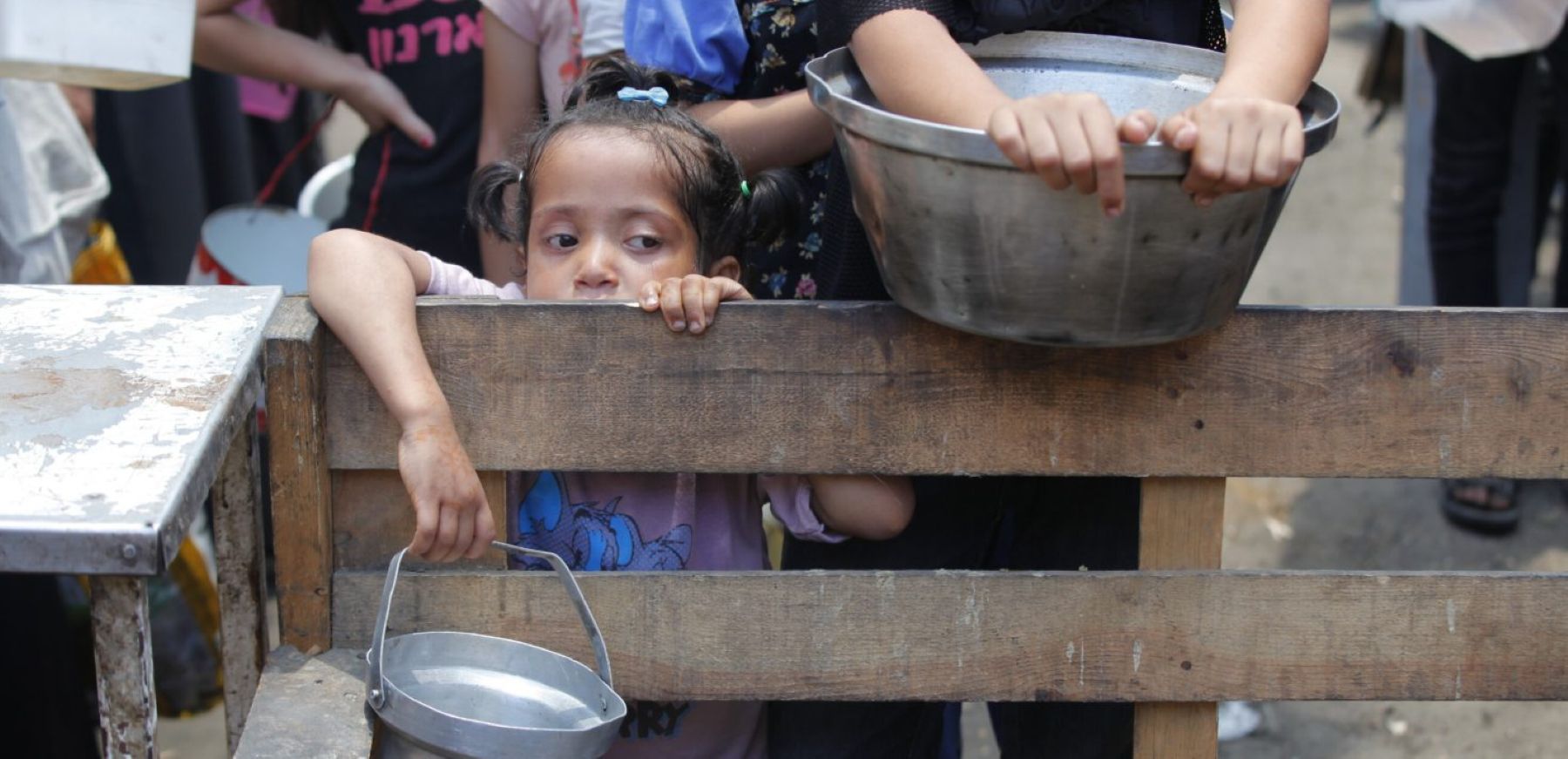 A Palestinian child is seen waiting with an empty pot as organizations distribute hot meals to Palestinians in Nuseirat refugee camp, who are struggling with hunger due to Israel's attacks on Gaza and closed borders in Deir al-Balah, Gaza, on June 02, 2025. Photo by Moiz Salhi/Anadolu via Getty Images.