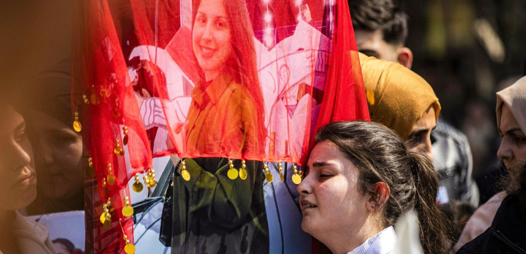 A woman reacts next to one of the pictures of victims of a recent wave of sectarian violence targeting Syria's Alawite minority in the west of the country along the Mediterranean sea coast, during a protest condemning the attacks in Syria's northeastern city of Qamishli on March 11, 2025. Photo by DELIL SOULEIMAN/AFP via Getty Images.