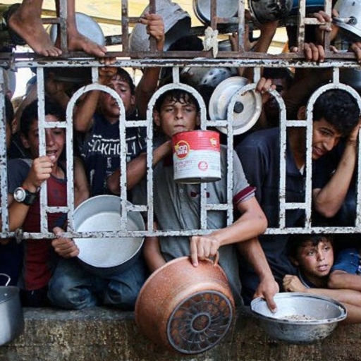 Palestinians wait for a meal at a charity kitchen in the Mawasi area of Khan Yunis in the southern Gaza Strip on July 22, 2025. Photo by AFP via Getty Image