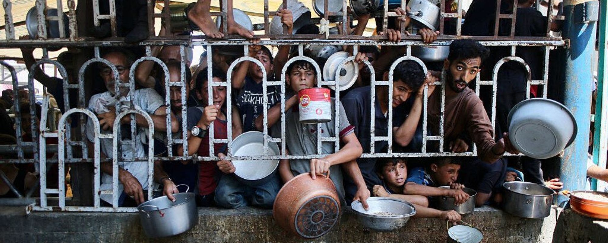 Palestinians wait for a meal at a charity kitchen in the Mawasi area of Khan Yunis in the southern Gaza Strip on July 22, 2025. Photo by AFP via Getty Image