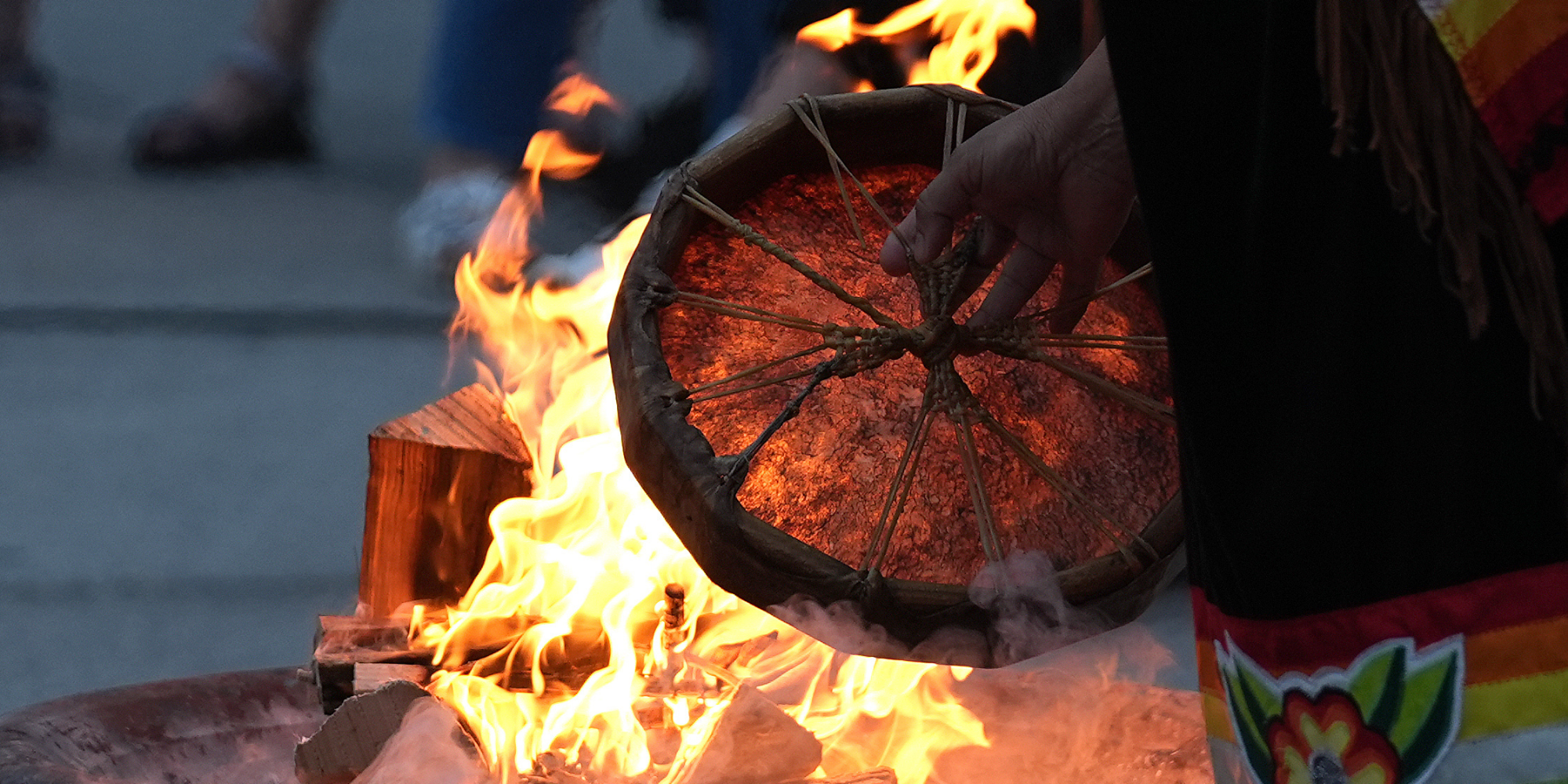 Elder Kim Wheatley heats the drum by the fire during the annual Sunrise Ceremony to mark National Indigenous Peoples Day at Nathan Phillips Square in Toronto, Ontario on June 21, 2024. (Photo by Mert Alper Dervis/Anadolu via Getty Images)