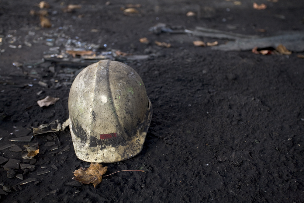 A white, dirt-covered hard hat on the muddy ground