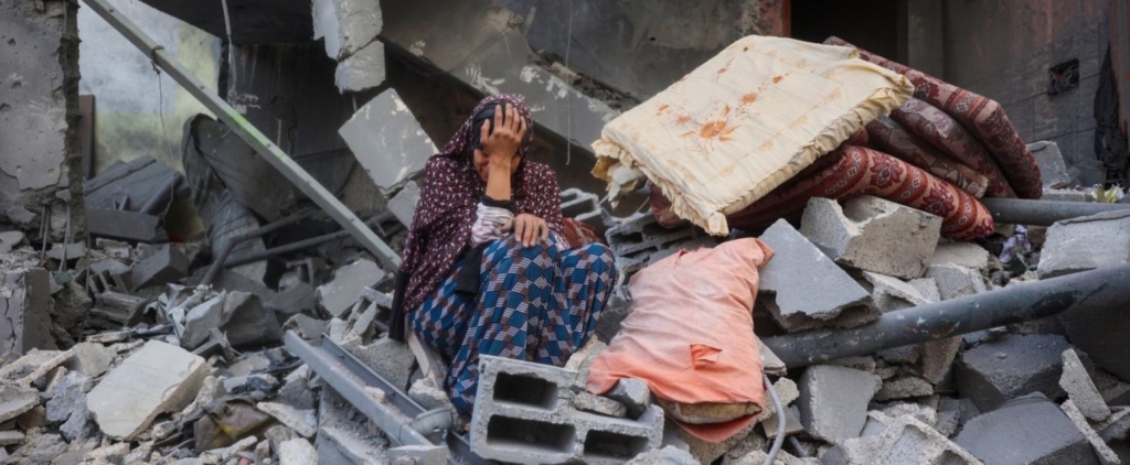 A woman cries while sitting on the rubble of her house, destroyed in an Israeli strike, in the Nuseirat refugee camp in central Gaza Strip on March 18, 2025. Photo by EYAD BABA/AFP via Getty Images.