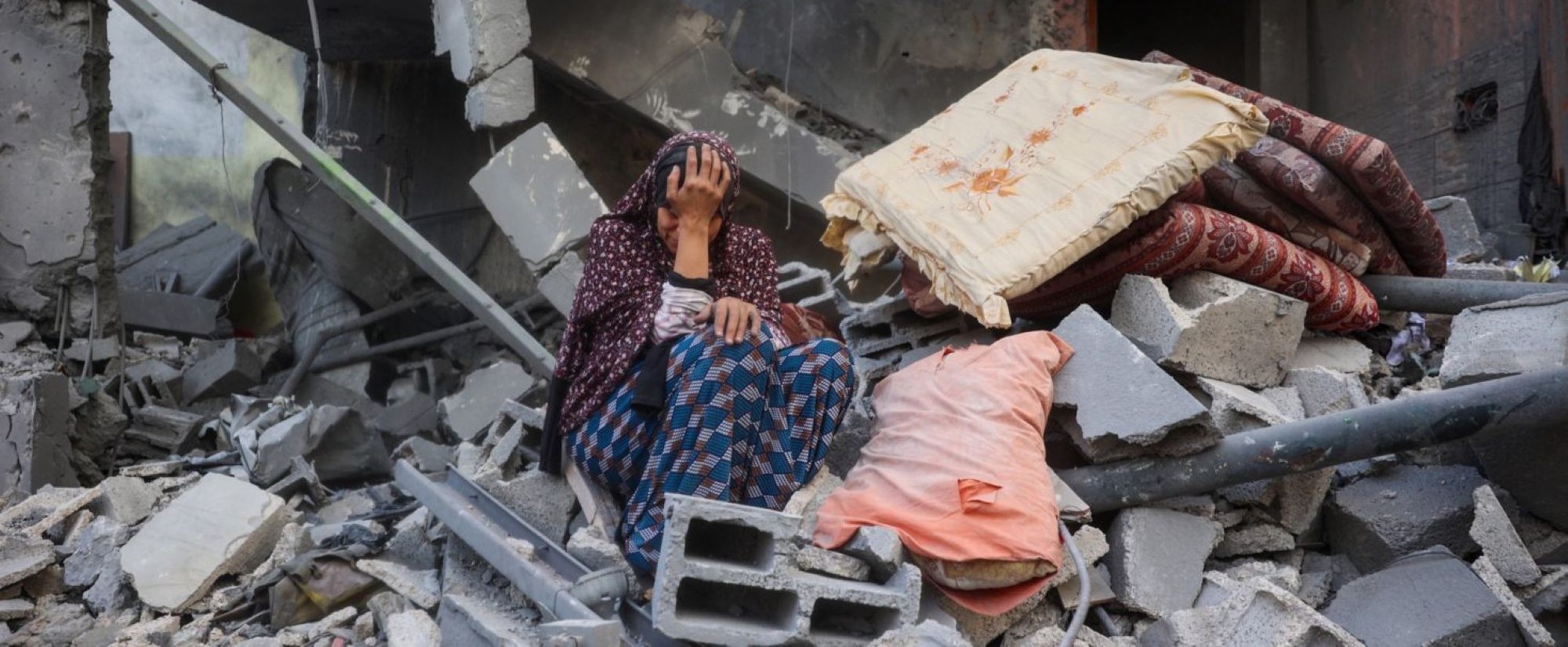 A woman cries while sitting on the rubble of her house, destroyed in an Israeli strike, in the Nuseirat refugee camp in central Gaza Strip on March 18, 2025. Photo by EYAD BABA/AFP via Getty Images.