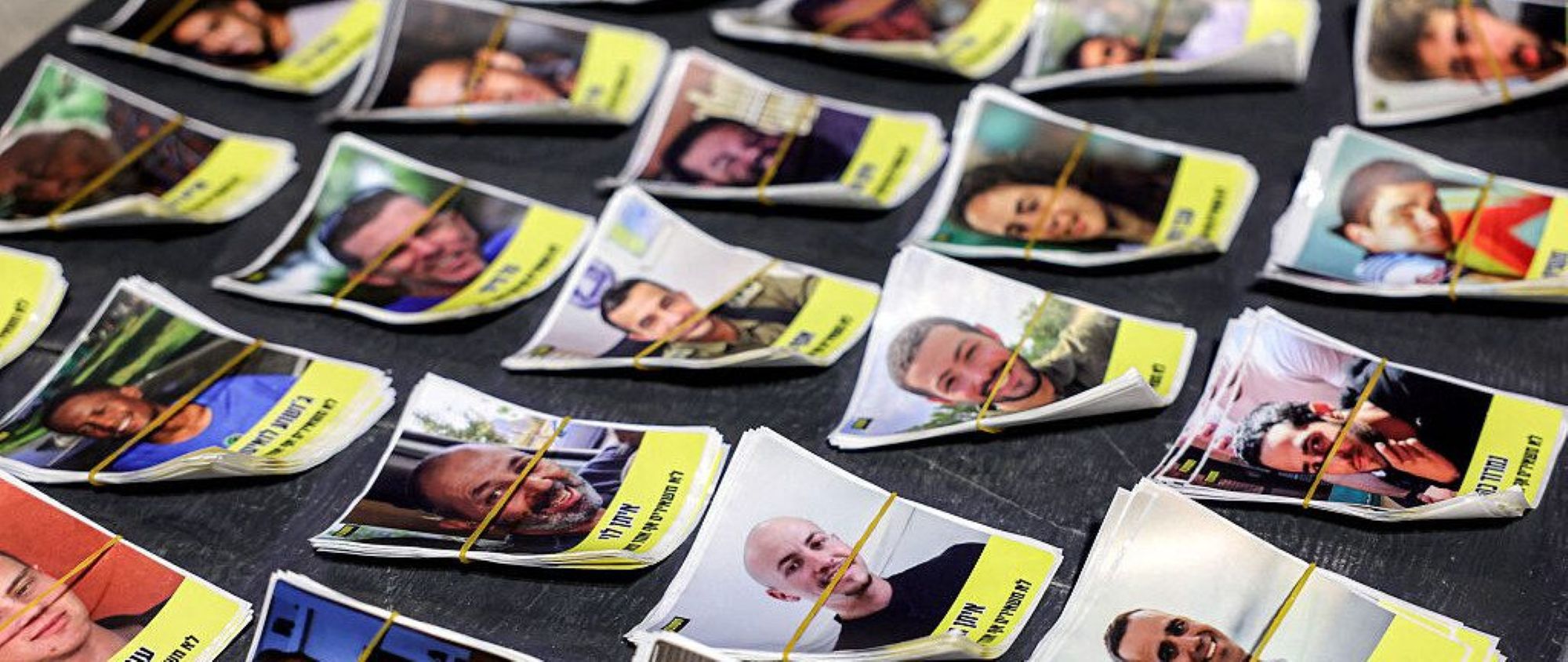 Cards with photos and names of Israeli hostages. Photo by JACK GUEZ/AFP via Getty Images.