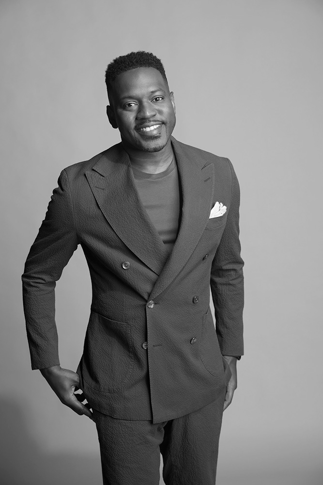 Donnovan Bennett in a suit smiling.