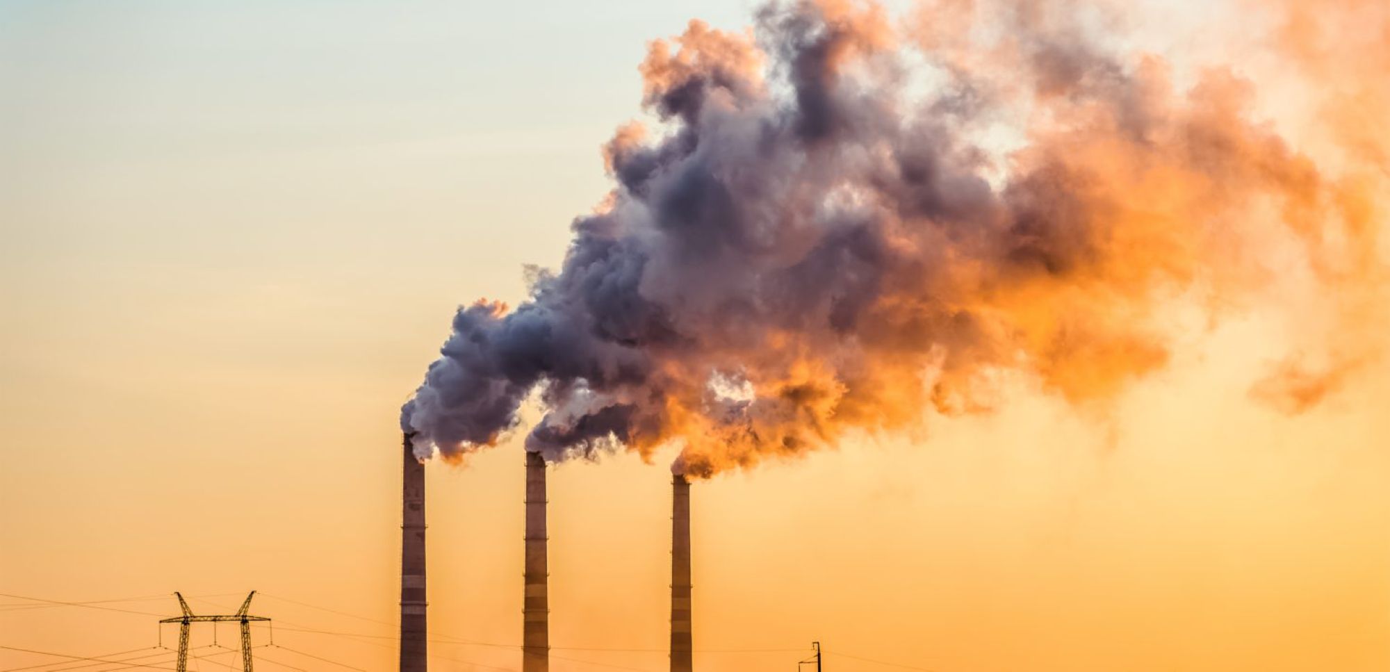 Sunset over the industrial city. Factory chimneys smoke. Photo by Getty Images/iStockphoto.