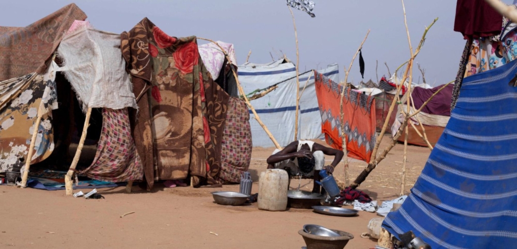 A displaced Sudanese man who fled El-Fasher after the city fell to the Rapid Support Forces (RSF), washes his hair outside a makeshift shelter in the Um Yanqur camp, located on the southwestern edge of Tawila, in war-torn Sudan's western Darfur region on November 3, 2025. Photo by AFP via Getty Images.
