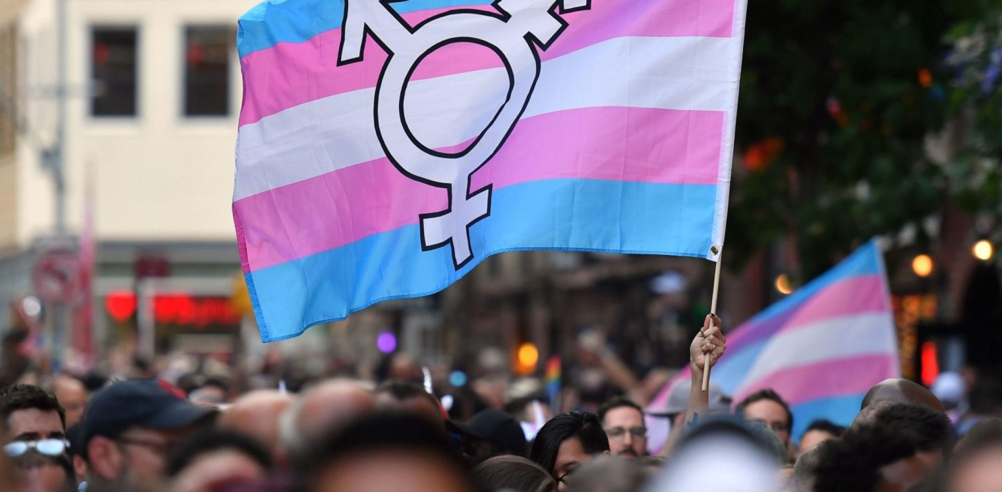A person holds a transgender pride flag as people gather on Christopher Street outside the Stonewall Inn for a rally to mark the 50th anniversary of the Stonewall Riots in New York, June 28, 2019. Photo by ANGELA WEISS/AFP via Getty Images.