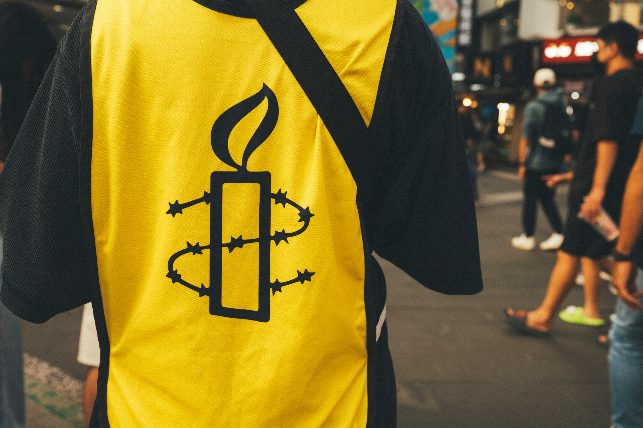 Amnesty logo embossed on a yellow background