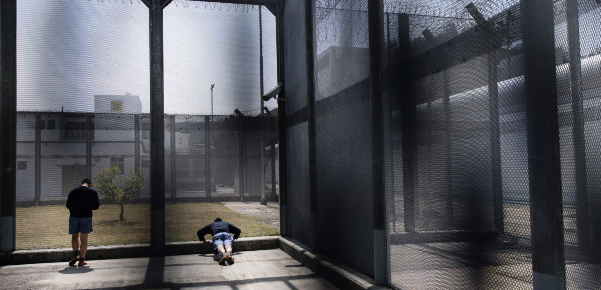 Inmates take part in their daily exercise routines in a secured outdoor area in Stanley Prison in Hong Kong in March 2017. Photo by ANTHONY WALLACE/AFP via Getty Images.